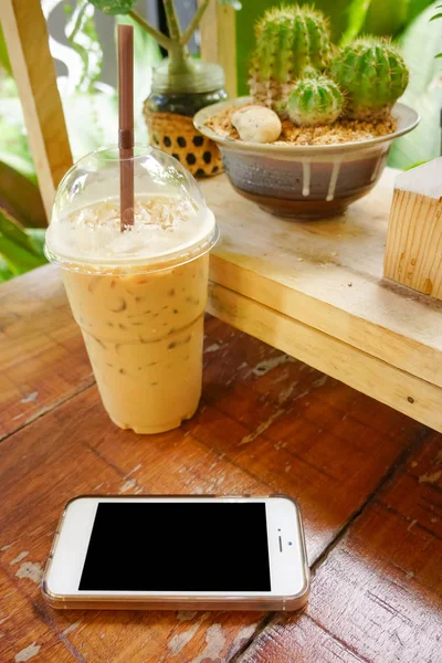 mobile phone with class of iced cappuccino on the table, coffee