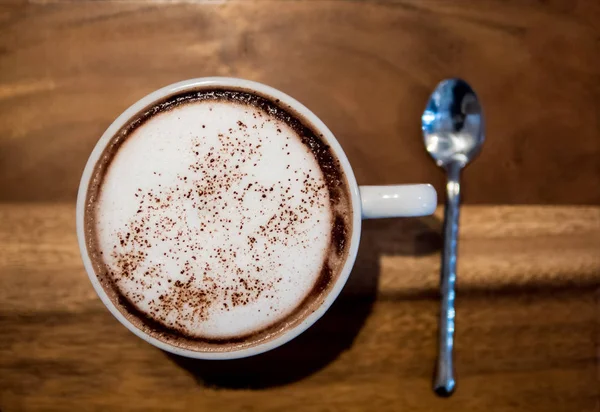 Chocolate quente em uma xícara branca, na mesa de madeira — Fotografia de Stock