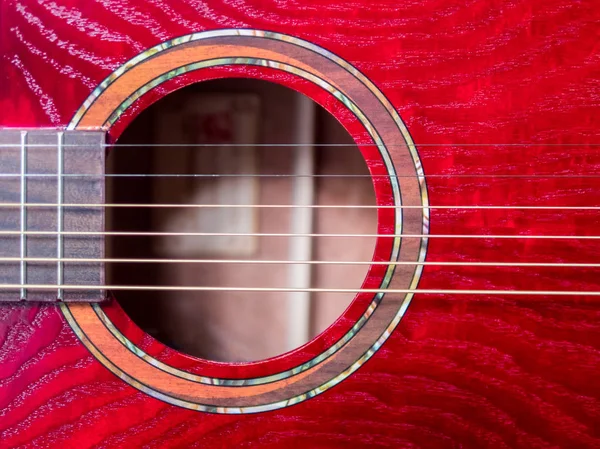acoustic guitar sound hole, red wood, close up shot