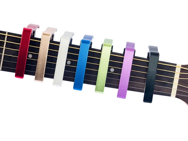 Farbenfroher Capo auf Gitarrengriffbrett, weißer Hintergrund, Nahaufnahme — Stockfoto