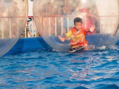 İçinde bir yüzen su topu, Zo yürüyüş oynayan genç Asyalı çocuk