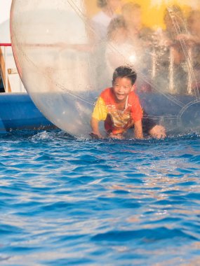 İçinde bir yüzen su topu yürüyüş oynayan genç Asyalı çocuk