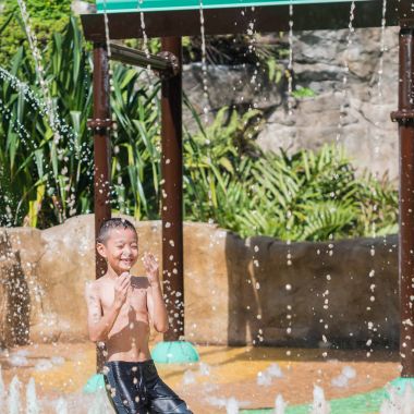 Asyalı çocuk küçük çocuk oyun parkı fou su ile eğleniyor