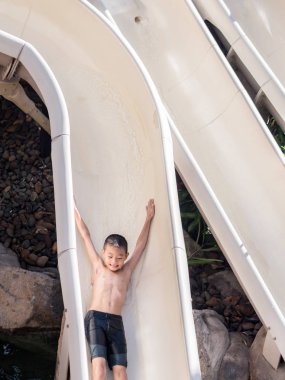 Asyalı çocuk havuza kaymak oynamak için bekliyor