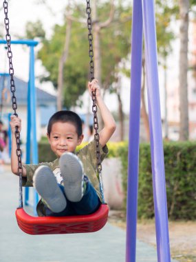 Mutlu bir çocukluk, Asya bebek çocuk açık salıncak üzerinde oynamak