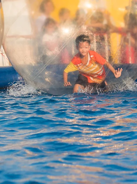 Joven asiático chico jugando dentro un flotante agua caminar pelota — Foto de Stock