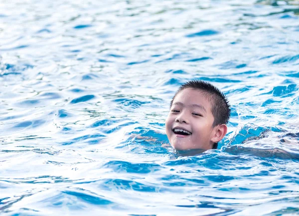 Asiático chico está jugando en la piscina, flotar — Foto de Stock