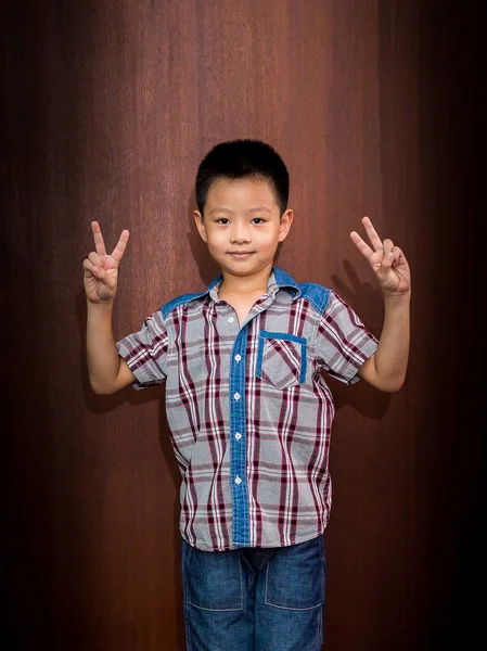 Potret bahagia anak kecil menunjukkan jari-jari atau gerakan kemenangan — Stok Foto