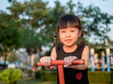 Mutlu çocuk, bir tahterevalli üzerinde oynayan Asya bebek çocuk 