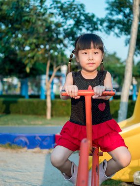Mutlu çocuk, bir tahterevalli üzerinde oynayan Asya bebek çocuk 