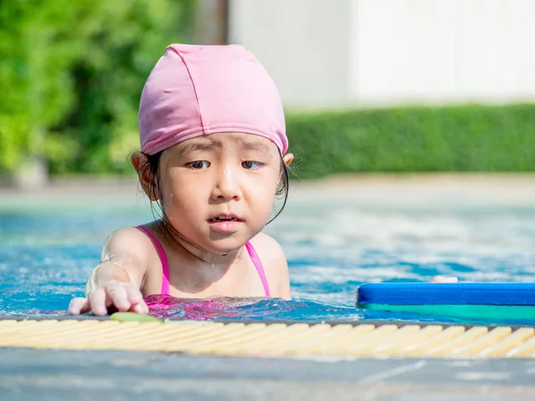 Menina asiática está jogando na piscina, luz do sol — Fotografia de Stock