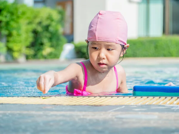 Menina asiática está jogando na piscina, luz do sol — Fotografia de Stock