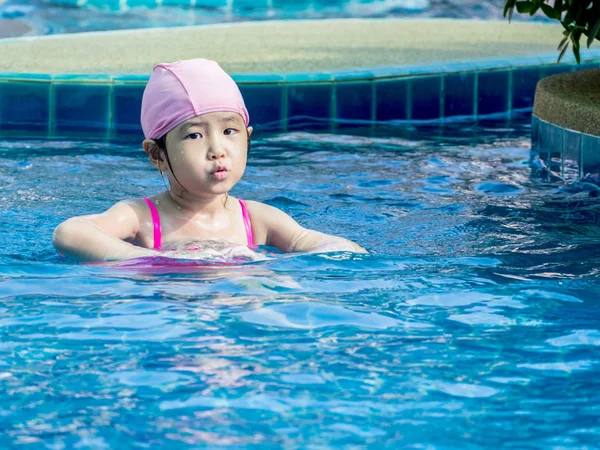 Menina asiática está jogando na piscina, luz do sol — Fotografia de Stock