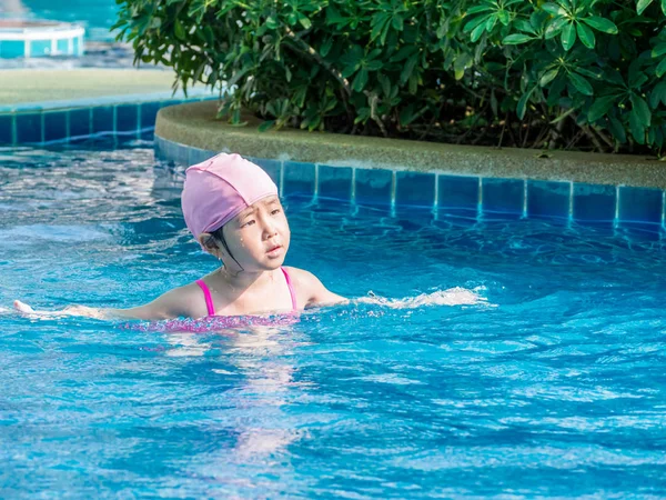 Asiatische Mädchen ist spielen in die pool, sonniges Licht — Stockfoto