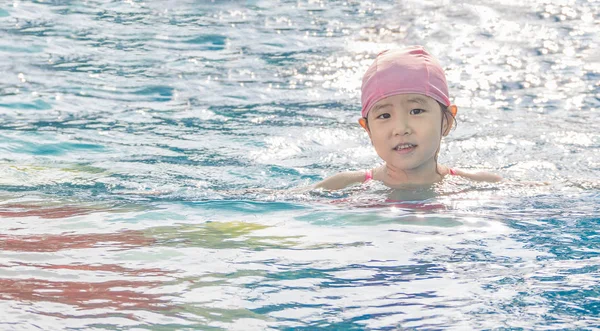Menina asiática está jogando na piscina — Fotografia de Stock