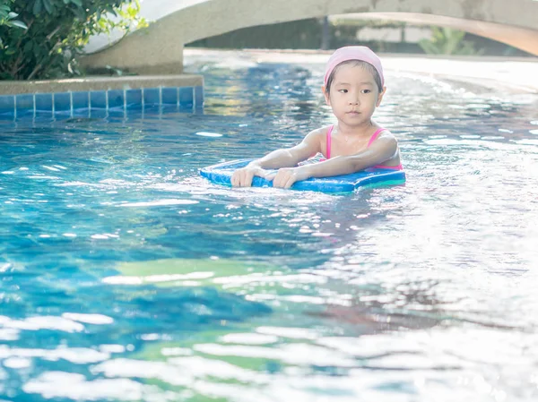 Asiatische Mädchen spielt im Pool, Sonnenuntergang Licht — Stockfoto