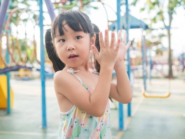 Oyun parkında, oynayan Asya bebek çocuk alkış onun eller eylem