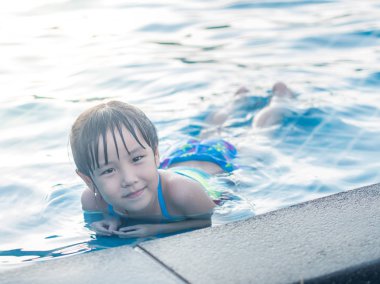 Asyalı kız havuzda bırakmasını oynuyor