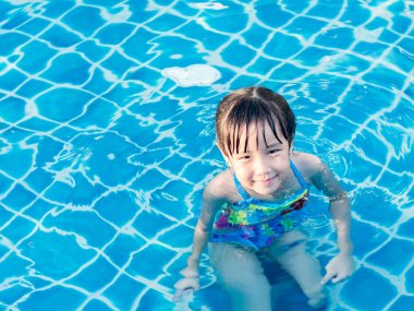 Asyalı kız havuzda günbatımı ışık oynuyor