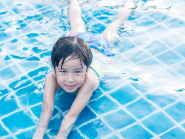 Asyalı kız havuzda bırakmasını oynuyor