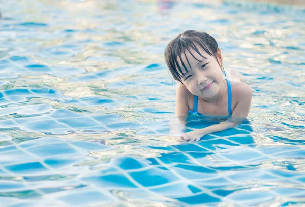 Asiática chica está jugando en la piscina, acostado — Foto de Stock
