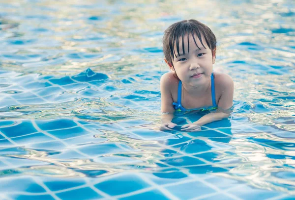 Menina asiática está jogando na piscina, deitado — Fotografia de Stock