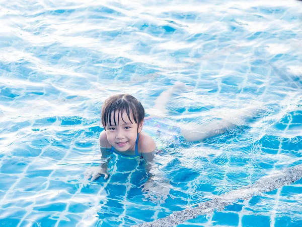 Asian girl is playing in the pool, laying down — Stock Photo, Image
