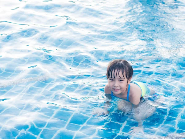 Menina asiática está jogando na piscina, deitado — Fotografia de Stock