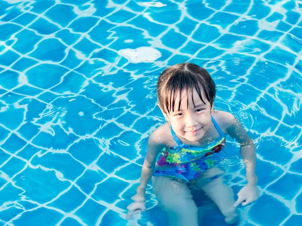 Asyalı kız havuzda günbatımı ışık oynuyor