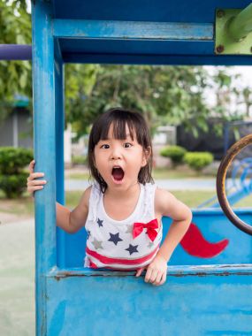 Happy asian baby child playing on playground, Girl gapes in surp clipart
