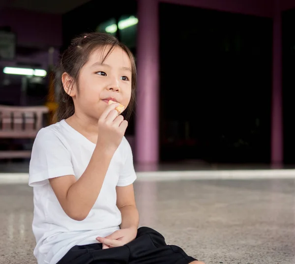 Pequeño asiático niño chica comer un cookie — Foto de Stock