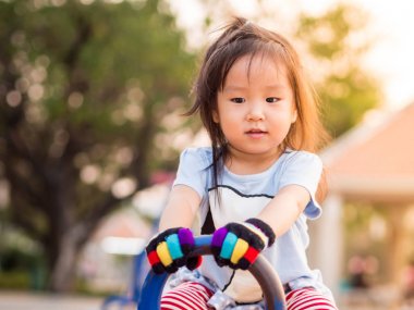 gün batımı aydınlık bir tahterevalli üzerinde mutlu Asyalı çocuk