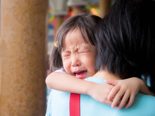 Азиатская девочка обнимает свою мать и плачет — стоковое фото