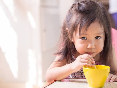 Güzel Asyalı kız pipetle içiyor