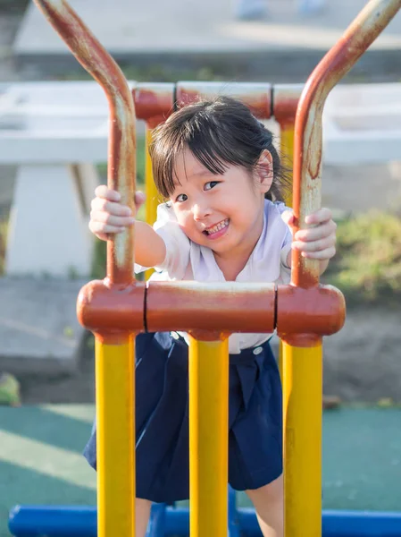 Счастливый малыш, ребенок в школьной форме, играющий на детской площадке — стоковое фото