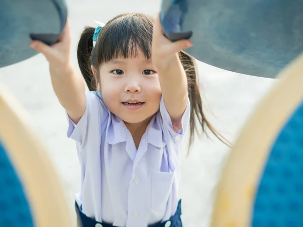 Счастливый малыш, ребенок в школьной форме, играющий на детской площадке — стоковое фото