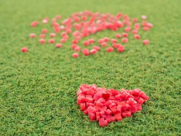 heart shape made from candle on artificial grass, selective focus