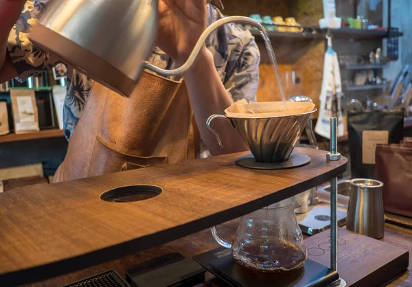 Hand drip coffee. Barista pouring water from silver teapot