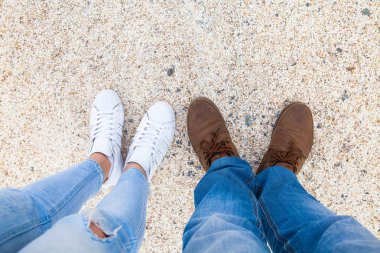 bacaklar bir erkek ve bir kadın ayakkabı kum üzerinde. Yukarıdan görüntülemek