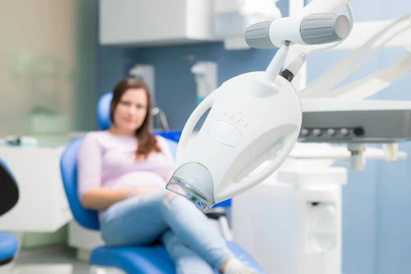 Teeth whitening device in a dental clinic, photo on the background of a woman sitting in a dental chair — Stock Photo, Image