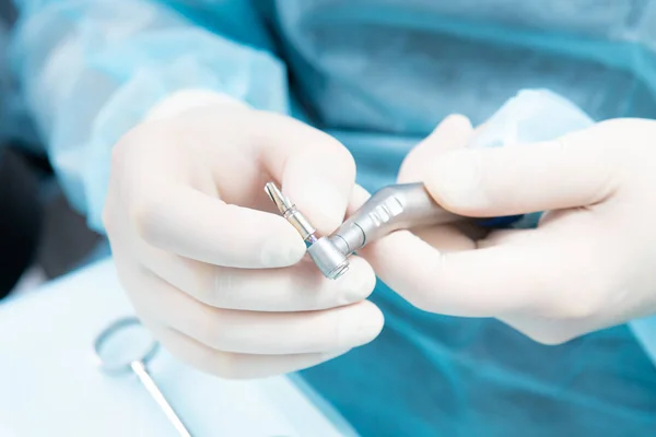 Mani del dentista in guanti sterili primo piano, con uno strumento di impianto . — Foto Stock