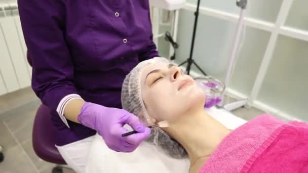 面部剥皮面膜 温泉美容治疗 在温泉沙龙接受美容师的面部护理的妇女 — 图库视频影像