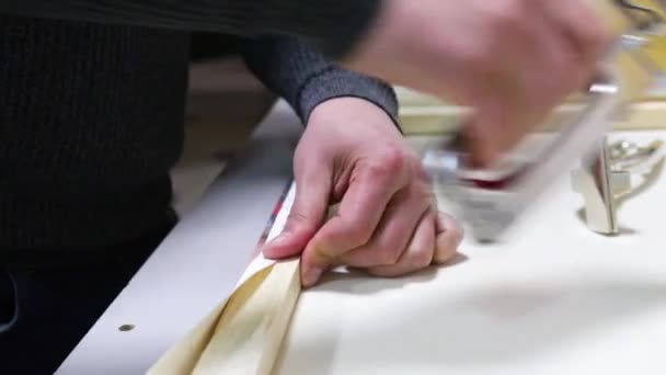 Toile étirant. Barre de civière en bois, agrafeuse, pinces à toile, mains masculines — Video