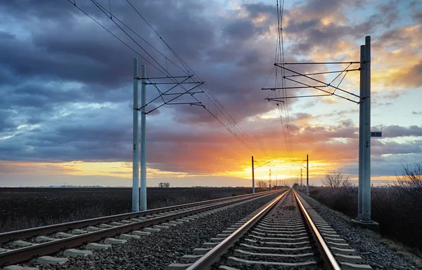 Železniční koleje v zapadajícím slunci — Stock fotografie