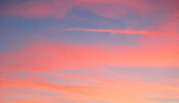 Червоне небо з блакитними хмарами — стокове фото