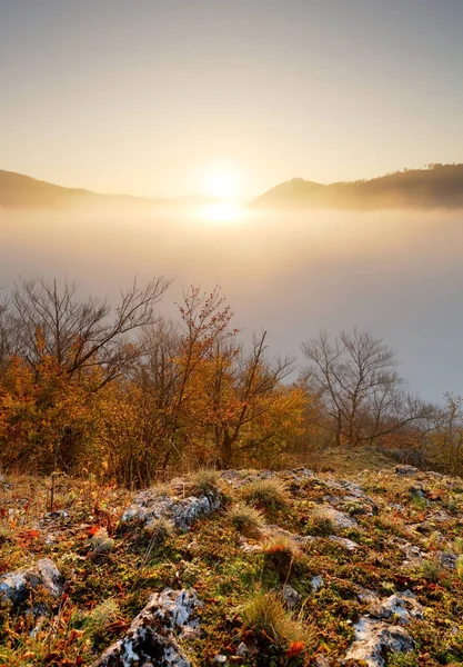 Sol sobre nubes niebla en paisaje montañoso al amanecer —  Fotos de Stock
