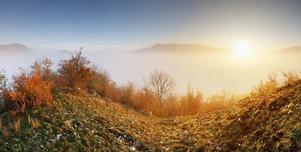 Sol sobre nubes niebla en paisaje montañoso al amanecer — Foto de Stock
