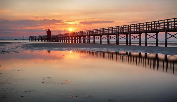 Houten Pier Die Leidt Naar Een Rode Vuurtoren Bij Zonsopgang — Stockfoto