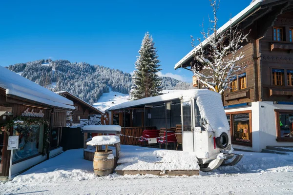 Vieux bus dans le village de Gstaad en hiver Image En Vente