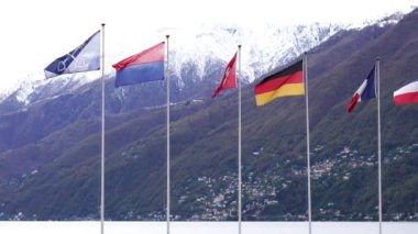 İsviçre Alpleri ve Maggiore Gölü önünde bayraklar